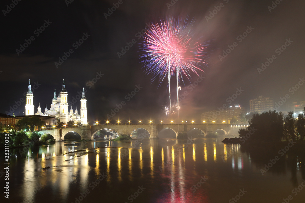 The fireworks during the 2018 Pilar festival next to the Pilar Cathedral and the Stone Bridge over the Ebro river, in Zaragoza, Aragon region, Spain