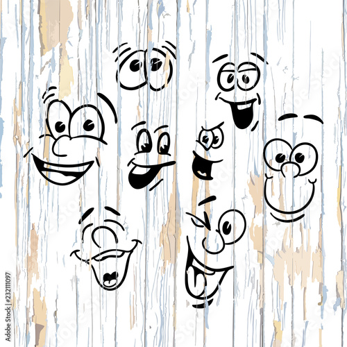 Smiling faces drawings on wooden background