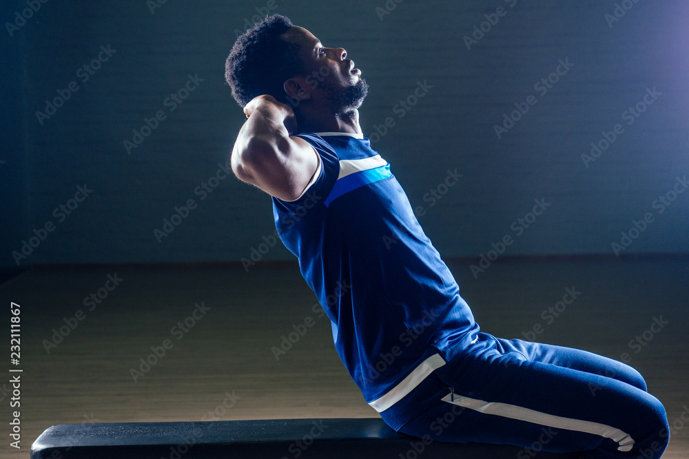 Black african american athletic man running on treadmills idoing exercises on muscle groups push up from the bench gym on black background