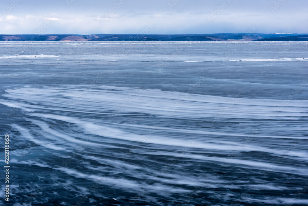 Fototapeta premium Lake Khubsugul is covered with ice and snow, strong cold, thick clear blue ice. Lake Khubsugul is a frosty winter day. Amazing place