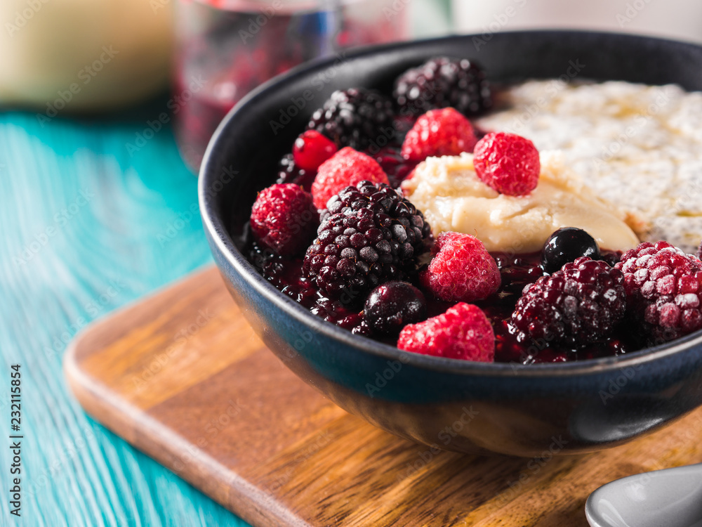 Vegan cashew milk Chia pudding with berries and home made almond butter served in a bowl on wooden board Vegan cashew milk Chia pudding with berries and home made almond butter served in a bowl on wooden board