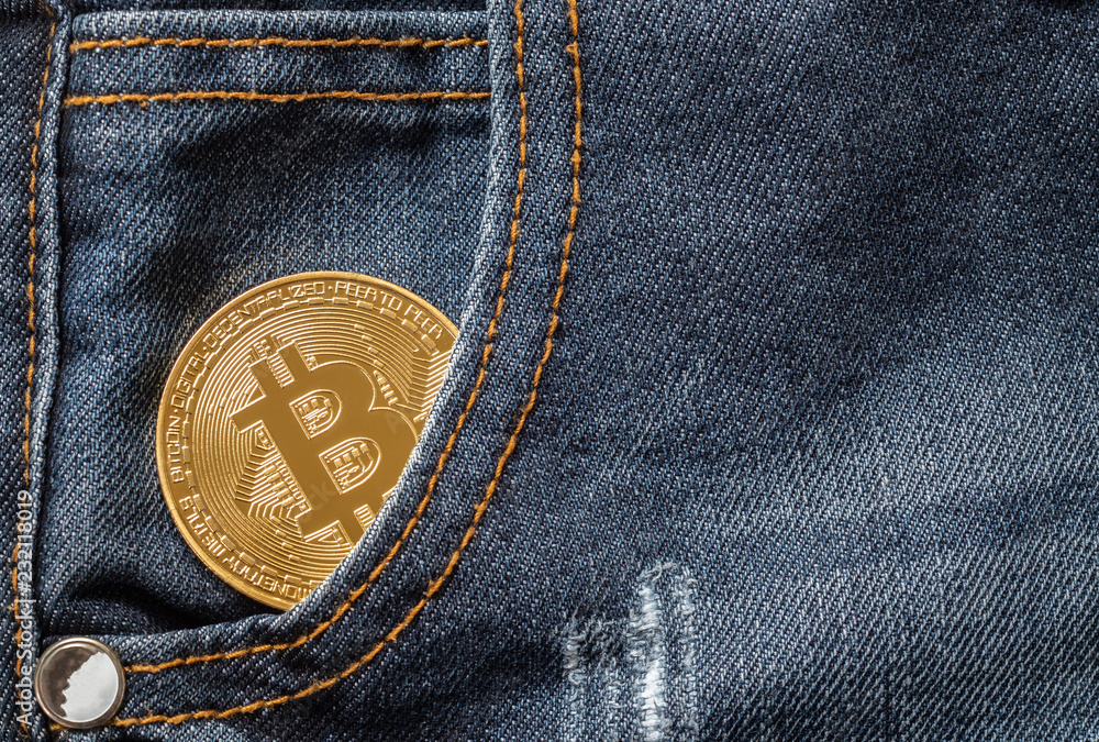 Close up of golden bitcoin in the denim jeans pocket Close up of golden bitcoin in the denim jeans pocket