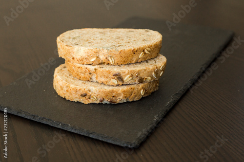 Wallpaper Mural Slices of homemade multigrain bread on black slate board Torontodigital.ca