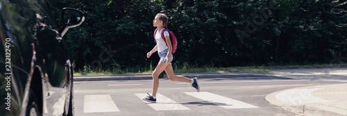 Panorama of car and girl running on pedestrian crossing to the school © Photographee.eu