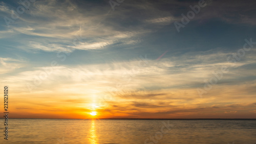 background of sunset on the sea  birds fly among the clouds lit by the rays of the sun
