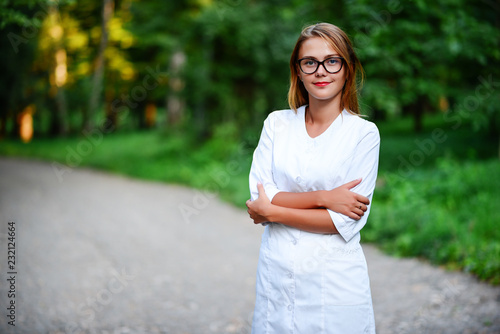 Obraz na płótnie Look super. a young girl who is a doctor stands outside, hands a w salonie