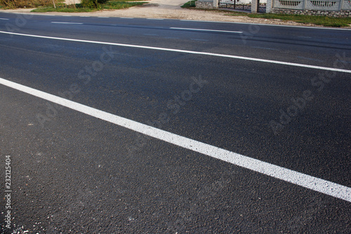 Asphalt road with marking lines white stripes © cezarksv