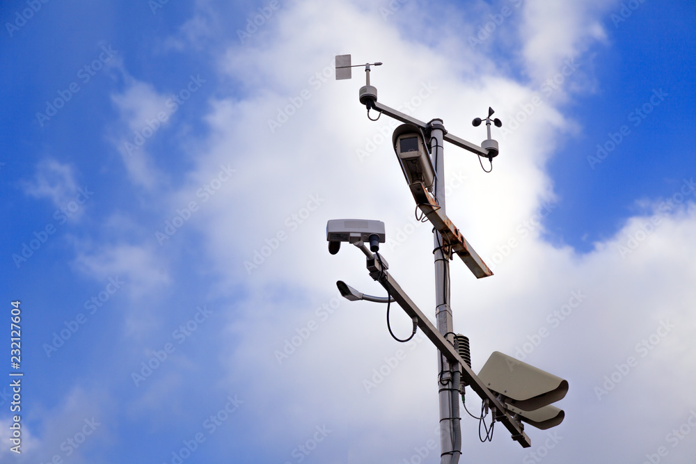 Gray iron pillar with surveillance cameras and speed control on a background of blue sky. Concept of safe driving on the highway Gray iron pillar with surveillance cameras and speed control on a background of blue sky. Concept of safe driving on the highway