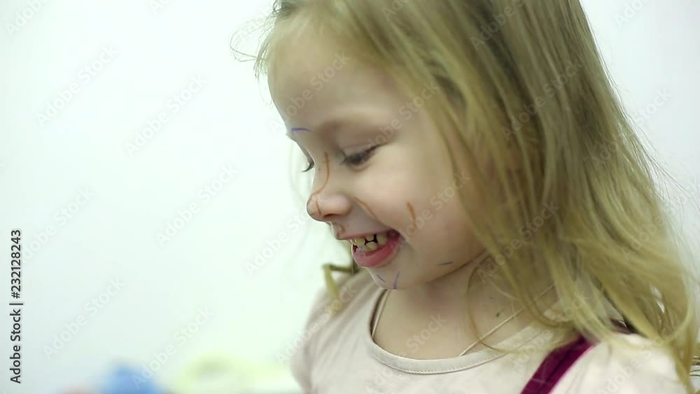 little girl with face painted with markers in different colors little girl with face painted with markers in different colors
