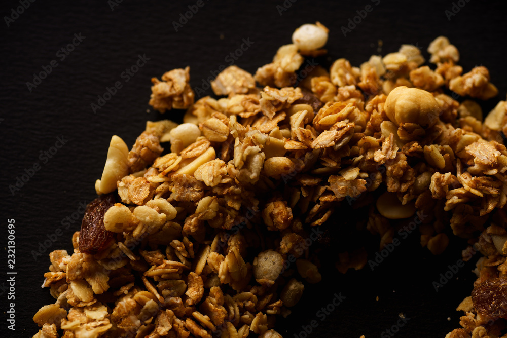 Overhead image of roasted granola laid in a form of a curve on black background. Design concept Overhead image of roasted granola laid in a form of a curve on black background. Design concept