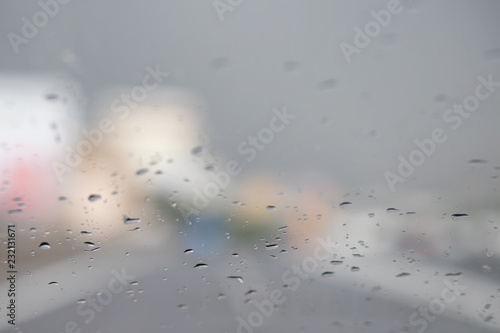 Drops Of Rain Drizzle on the glass windshield in the evening. street in the heavy rain. bokeh traffic road city. soft Focus. Please drive carefully, slippery road.