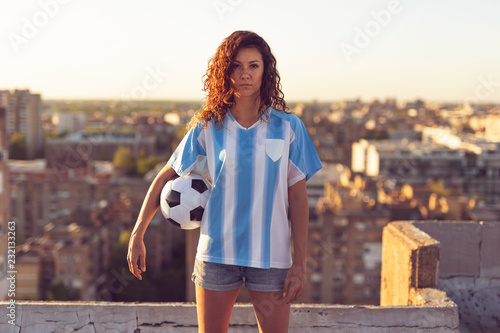 Woman in a football jersey holding a ball