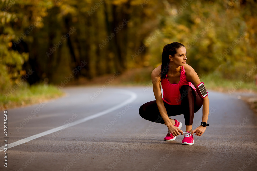 © BGStock72 - Young woman have a break during training in the autumn forest