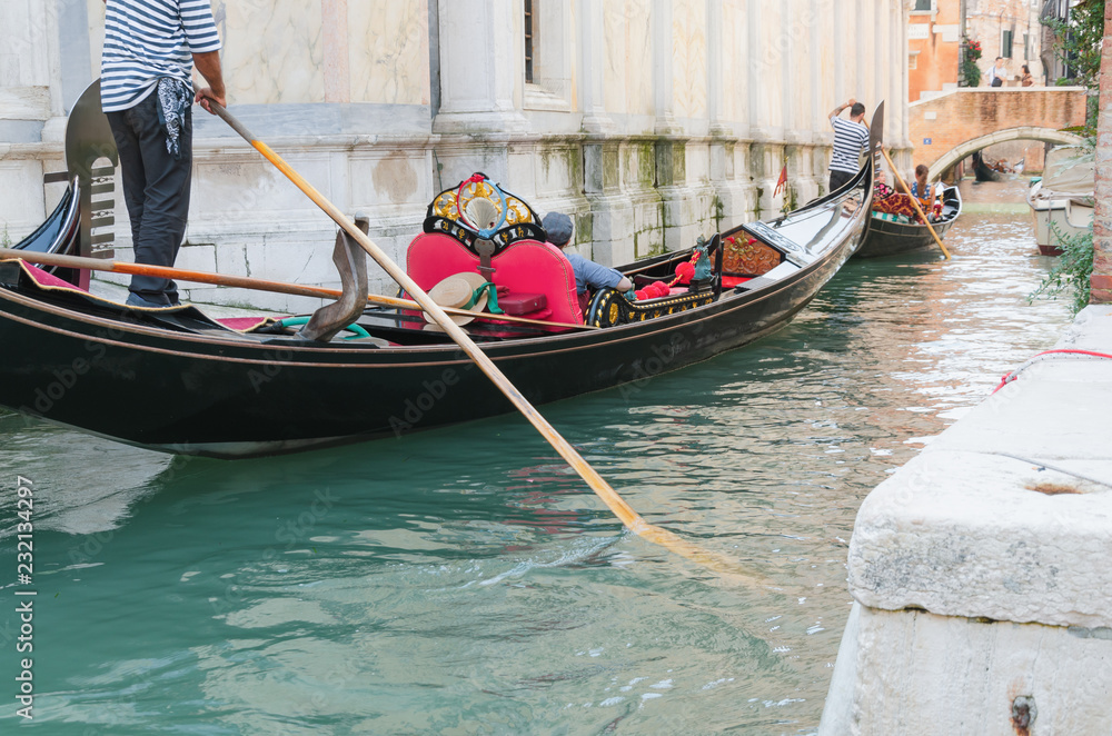 Venice channel and gondolier with passengers