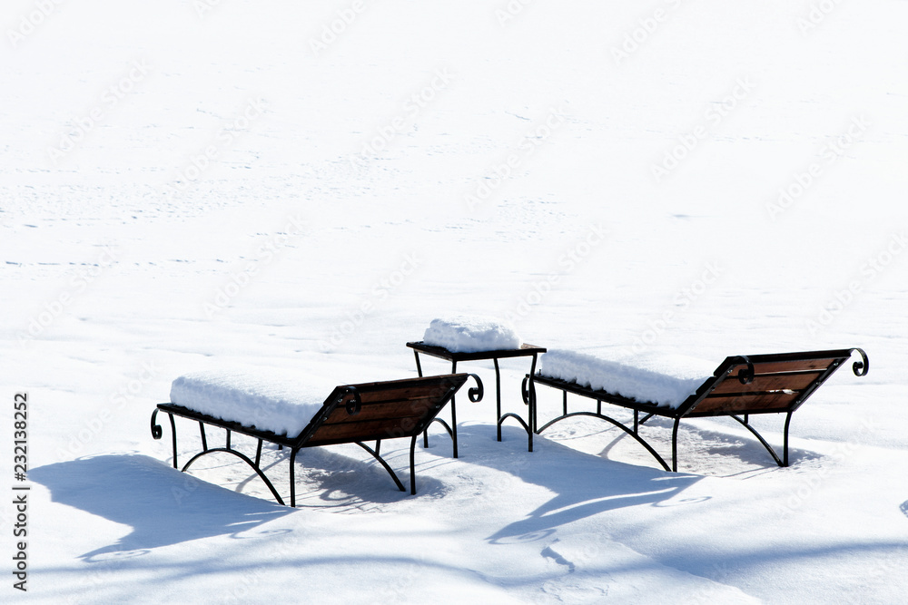 sun beds in the snow, sunbathing in the winter, Empty deckchair on the side of a ski slope,