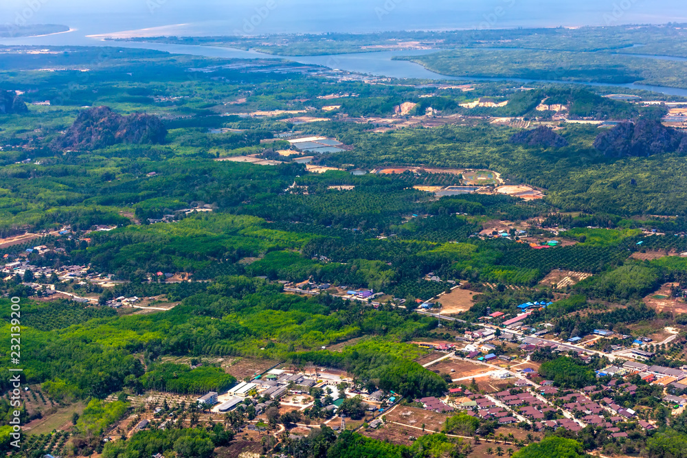 View of the Krabi province from the plane aircraft, the river flowing into the Adaman Sea, the rainforest, roads, houses from a bird's eye view. Krabi Town aerial view, Thailand.