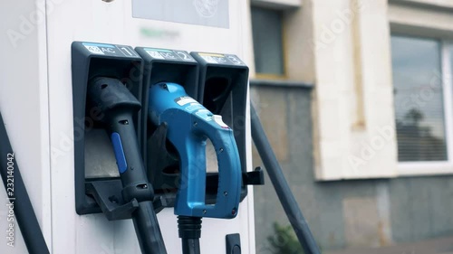 Wallpaper Mural Charging plugs hang on a special machine at a station, close up. Torontodigital.ca