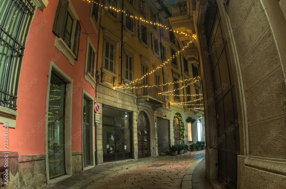 a narrow street in the historic center of Milan with Christmas decorations. Italy