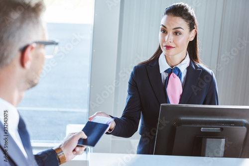 Foto businessman giving documents to female airport worker at check-in in airport