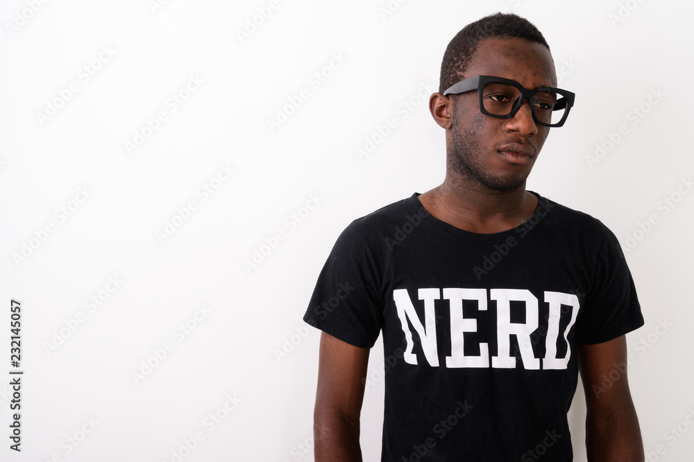 Studio shot of young black African geek man wearing Nerd shirt w Studio shot of young black African geek man wearing Nerd shirt w