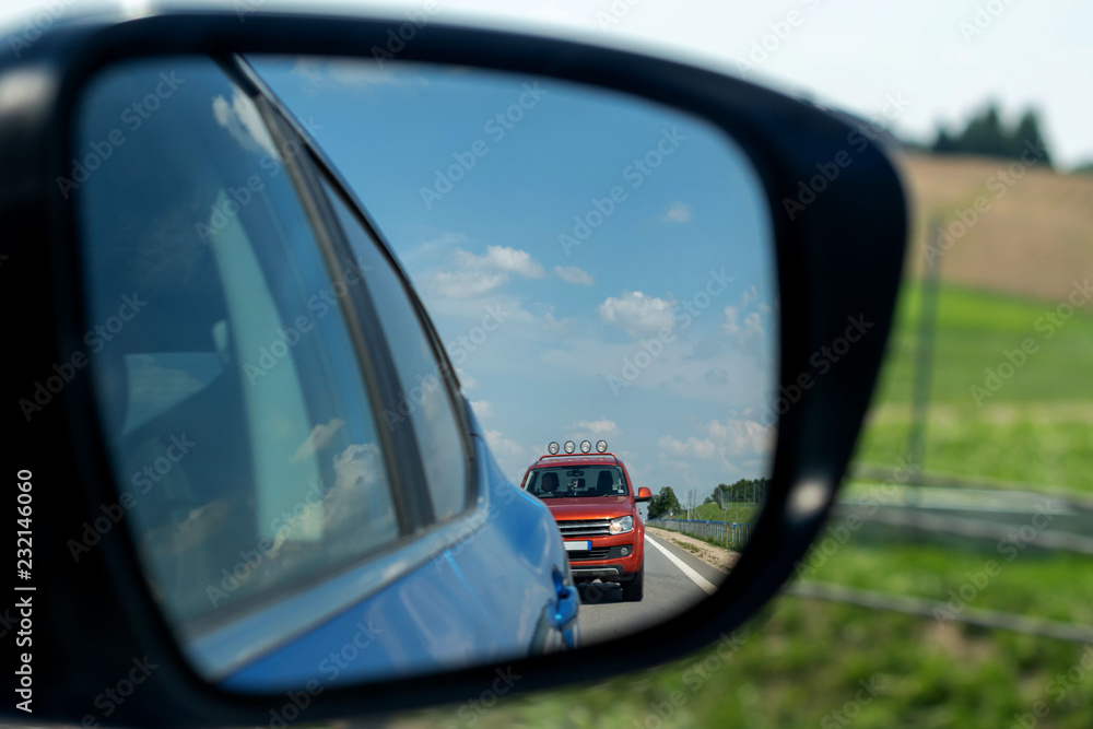 The rearview mirror of the car shows another car at the rear. The rearview mirror of the car shows another car at the rear.