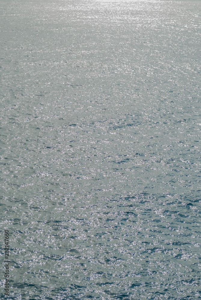 Sea surface of water with ripples, scattered back light, abstract textural background. Sea surface of water with ripples, scattered back light, abstract textural background.