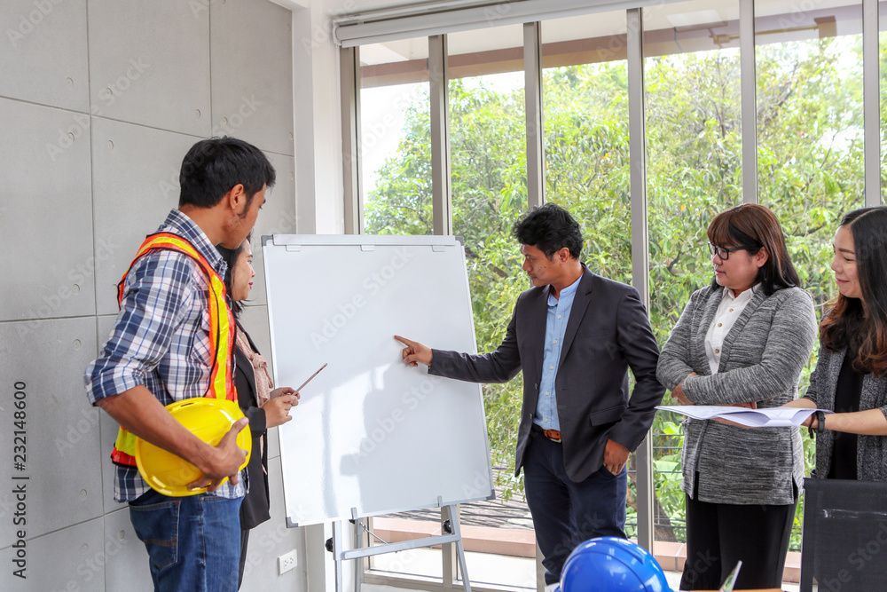 Executives are explaining plans on a whiteboard. Confident boss explaining something to employee. Planning of engineers and technicians. Engineers and Architects. Asian people in meeting room.