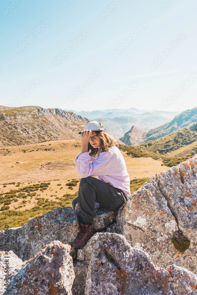 Woman on rock against mountains in sunlight Woman on rock against mountains in sunlight