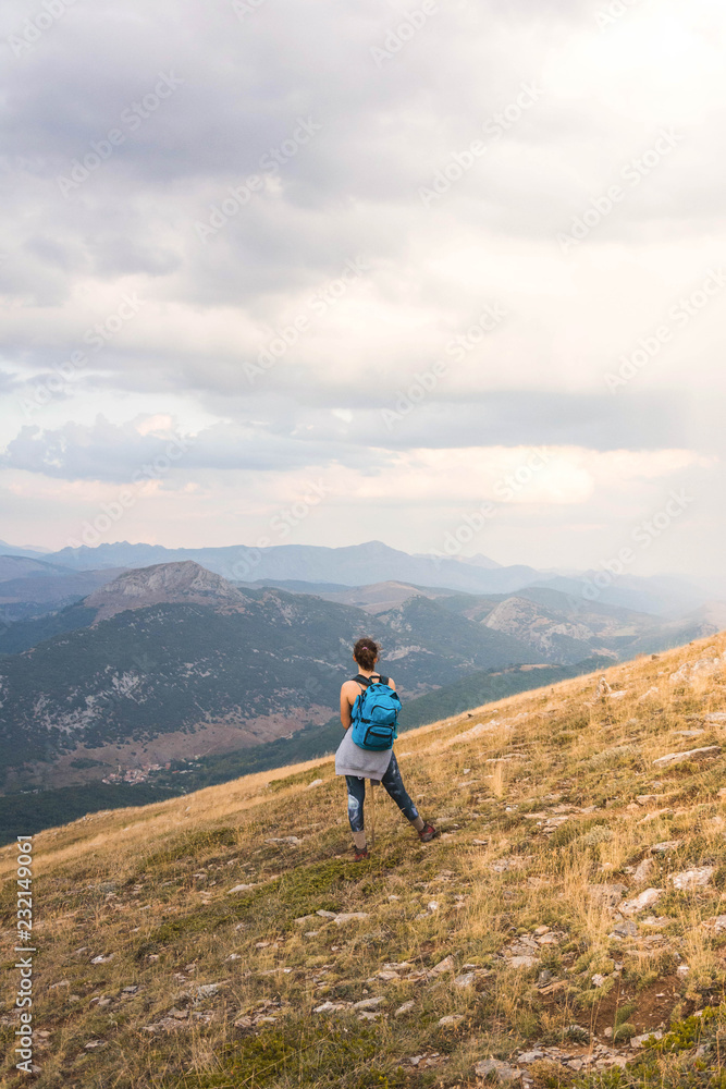 Woman with backpack against mountain range Woman with backpack against mountain range
