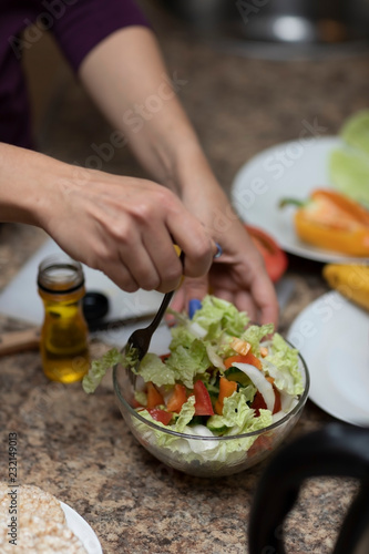 Fototapeta Naklejka Na Ścianę i Meble -  Female hand cuts vegetables for salad.