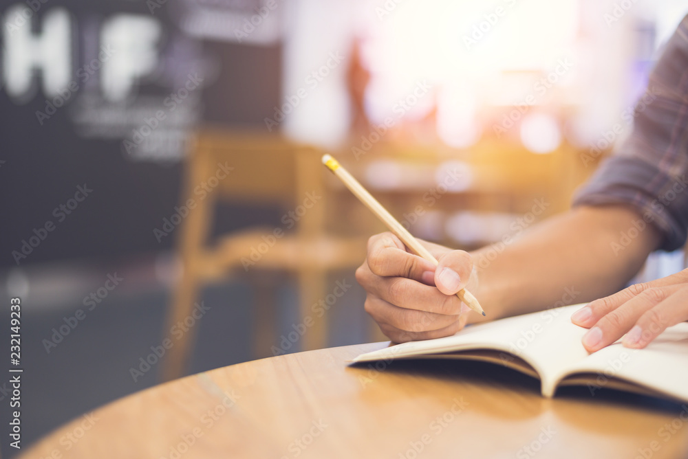Asian young businessman or student holding a pencil writing letter on paper at classroom in home or office,copy space,vintage tone. Asian young businessman or student holding a pencil writing letter on paper at classroom in home or office,copy space,vintage tone.