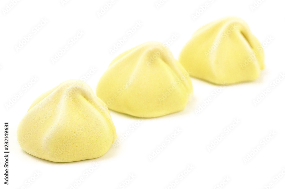 Line of Three Yellow Meringues on a White Background