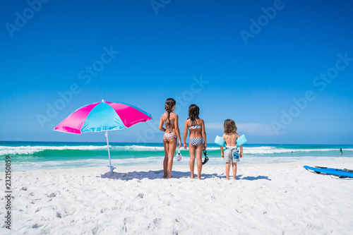 Three Kids on the Beach with an Umbrella