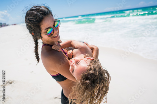 Woman Carrying Child on Beach