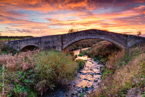 River Blyth under Bellasis Bridge, the humped-back stone bridge is grade 2 listed, seen here at sunset photo