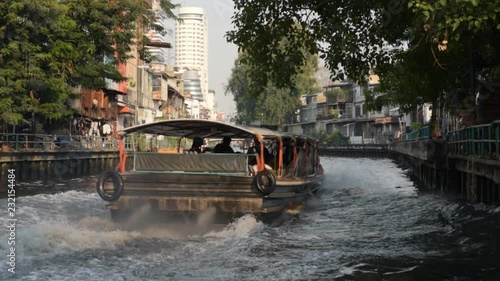Bangkok public boat rushes along a canal with noise, splash and traffic fumes. Near Phanfa Bridge pier. Sound, HD, 25 fps photo