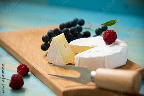 cheese camembert with raspberries and grapes on