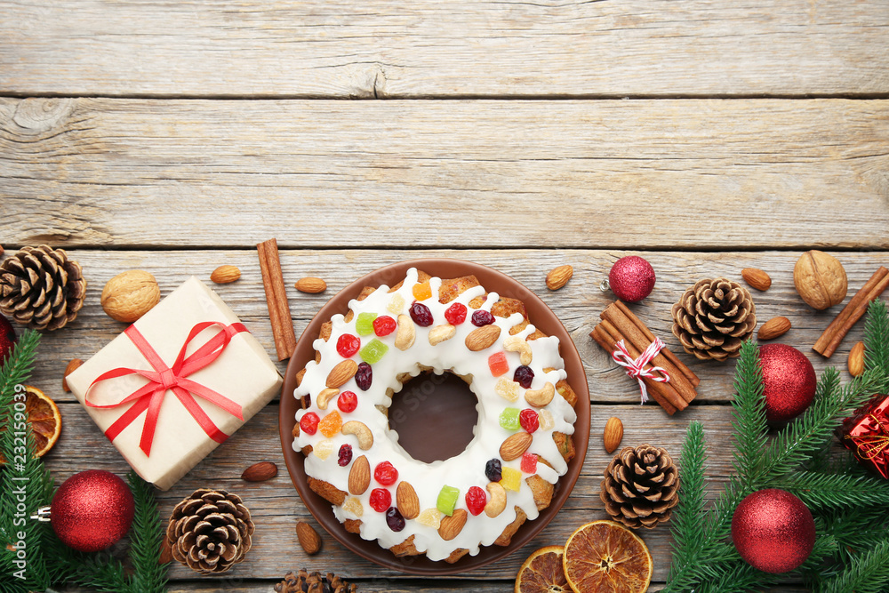 Bundt cake with fir-tree branches, baubles and gift boxes on wooden table Bundt cake with fir-tree branches, baubles and gift boxes on wooden table
