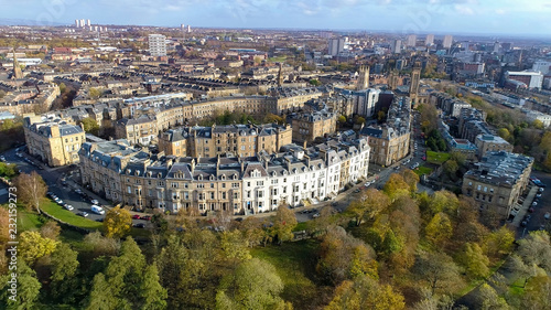 Low level aerial image over the autumn foliage of trees in Kelvingrove Park, Glasgow, to the elegant buildings of Park Circus.
