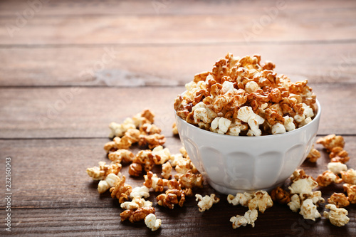 Caramel popcorn in bowl on wooden table
