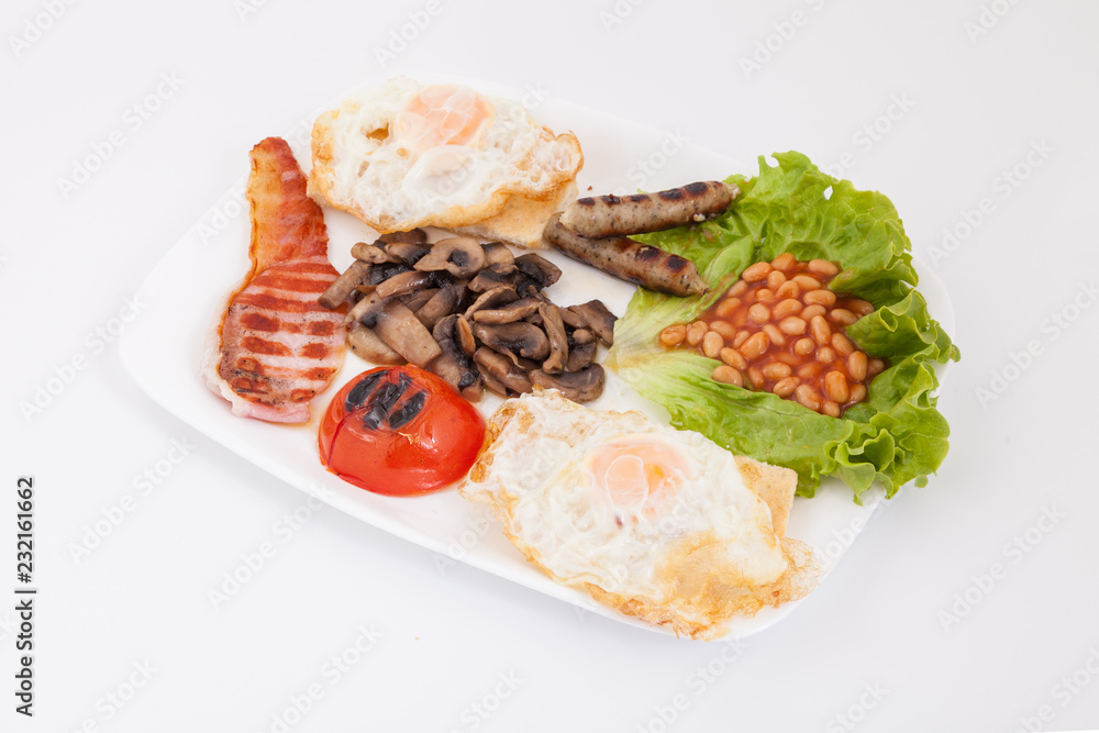 Full english breakfast. Bean, eggs , bacon slices, sausages, tomatoe and mushrooms on white plate