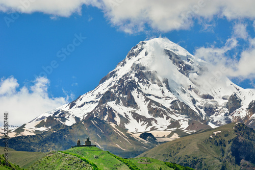 Mount Kazbek (5047m), the third-highest peak in Georgia, bordering Russia, with the Gergeti Trinity Church on its slopes. Khevi-Kazbegi region. Georgia, Caucasus photo