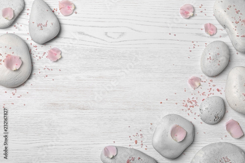 Photography Flat lay composition with spa stones and petals on wooden background