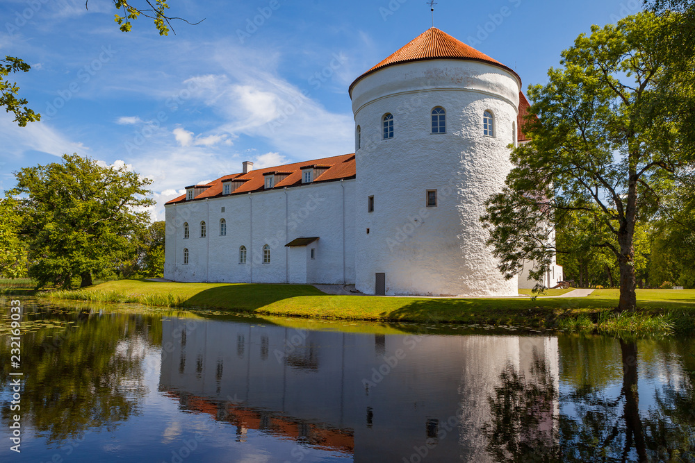 White castle Koluvere - saved medieval theasure of Estonia. Tower and wall with reflection in the pond White castle Koluvere - saved medieval theasure of Estonia. Tower and wall with reflection in the pond