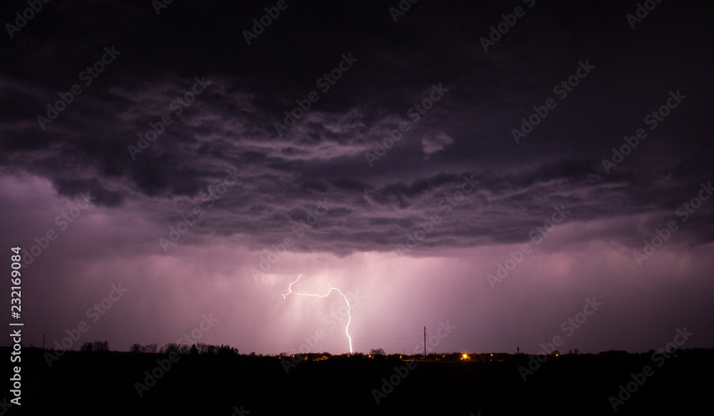 Lightning strike with purple sky over Sirvintos city in Lithuania