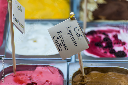 different varieties of ice cream are laid out in trays on the counter closeup photo