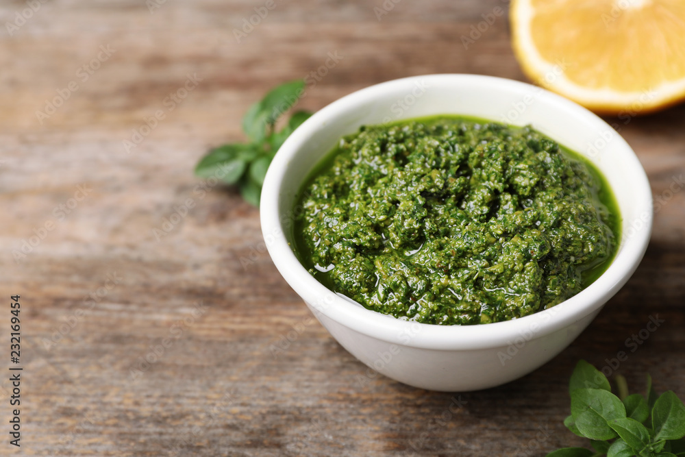 Homemade basil pesto sauce in bowl on table Homemade basil pesto sauce in bowl on table
