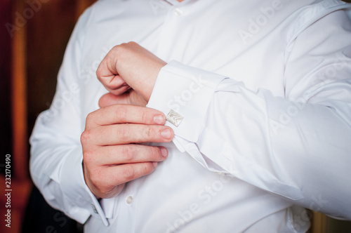 Groom holding hand on the cuff