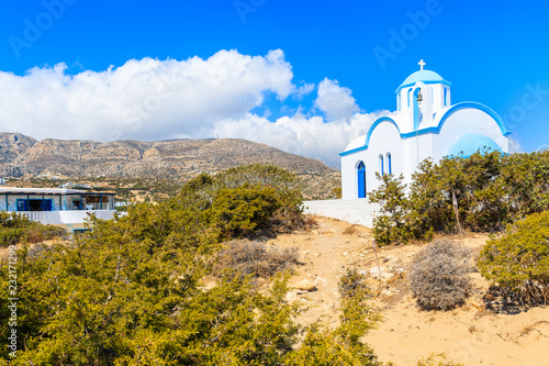 White chapel with mountains in background on sea coast in Ammopi village, Karpathos island, Greece