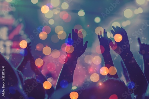 Fotografia Audience with hands raised at a music festival and lights